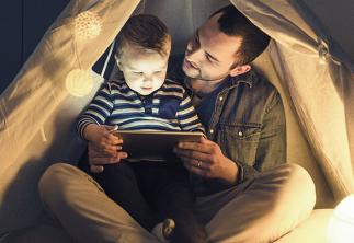 National Grid ESO - Electricity Explained - man and child reading under a tent