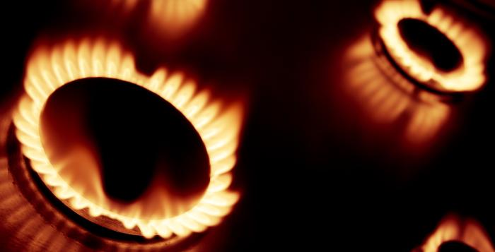 Four lit gas rings partially in view against a near-black background 