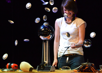 A person surrounded by small objects suspended in mid-air 