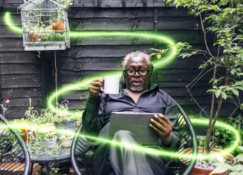 Man reading tablet in garden